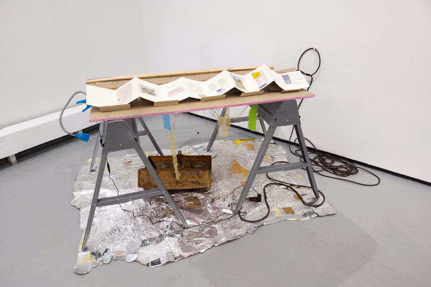 Buried Museum Book and Toolbox, 2014-2022. Thread, found objects, toolbox, tin foil, riso print, extension cord, reading light, and cardboard; 62 x 43 x 35 in. Photo: Allison Minto.