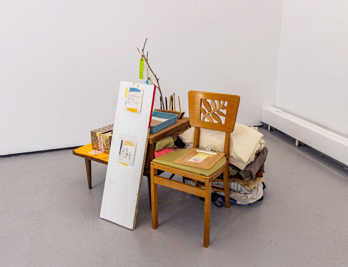 Letter Writing Station, 2022. My summer clothes, found and borrowed furniture and objects, wood, riso print, tree branch, cardboard, string, and fabric; 55 x 45 x 27 in. Photo: Meghan Olson.