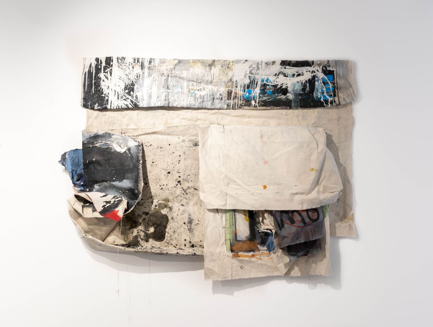 Ground Up, 2022. Spray paint, saliva, iodine, charcoal, acrylic, oil, oil pastel, pressure, staples, graphite, water, graphite, studio residue, canvas on drywall; 63 x 41 in. Photo: Allison Minto.
