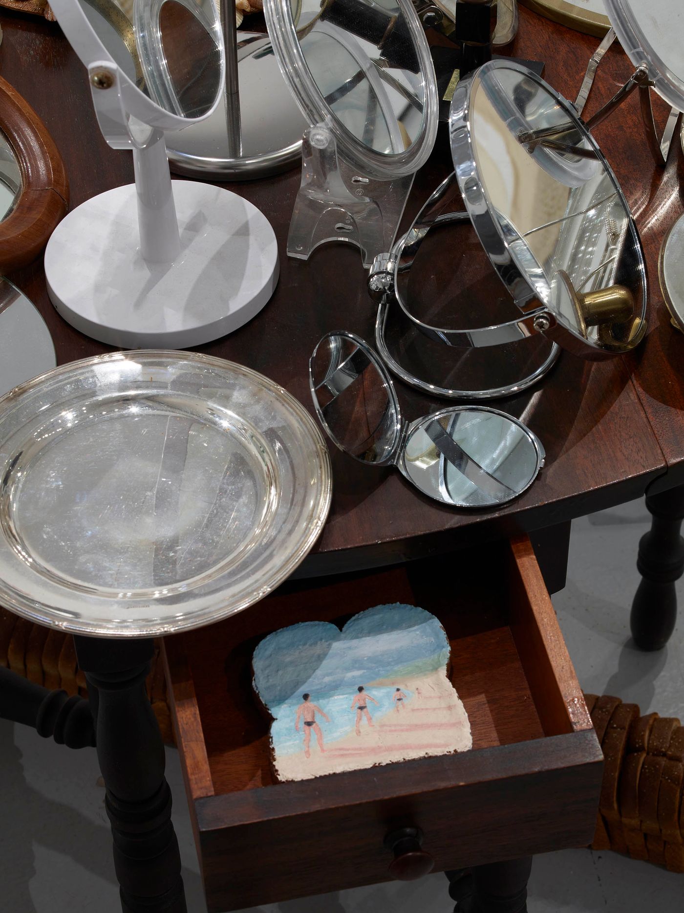 Incarnations (detail), 2022. Mirrors, silver plates, table, oil on toast in drawer. Photo: Merik Goma.
